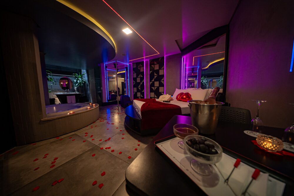 Suíte do Vis à Vis decorada com pétalas de rosa, hidromassagem e iluminação cênica para o pacote Romance